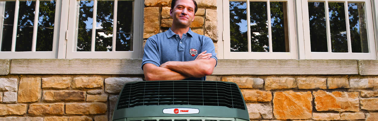 Trane Tech Standing Behind Ac Unit